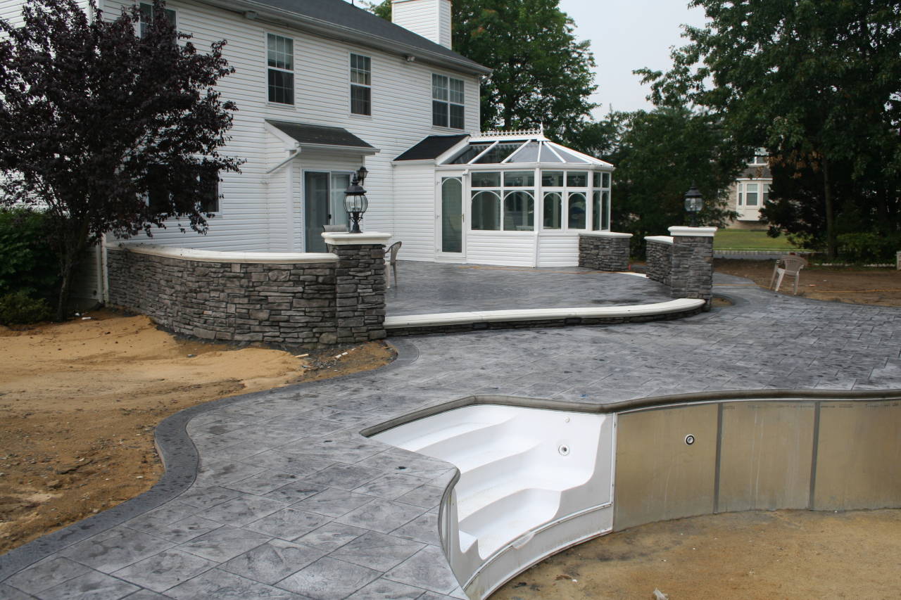 Stamped concrete pool patio, retaining walls, and backyard hardscape